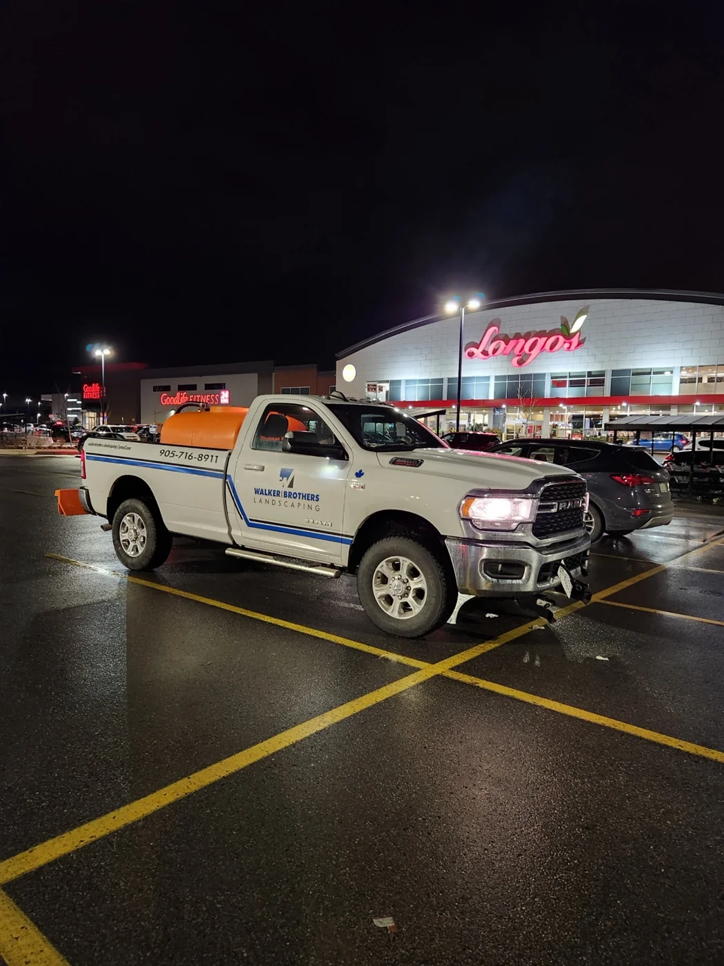 White Walker Brothers branded RAM work truck parked beneath lights at night